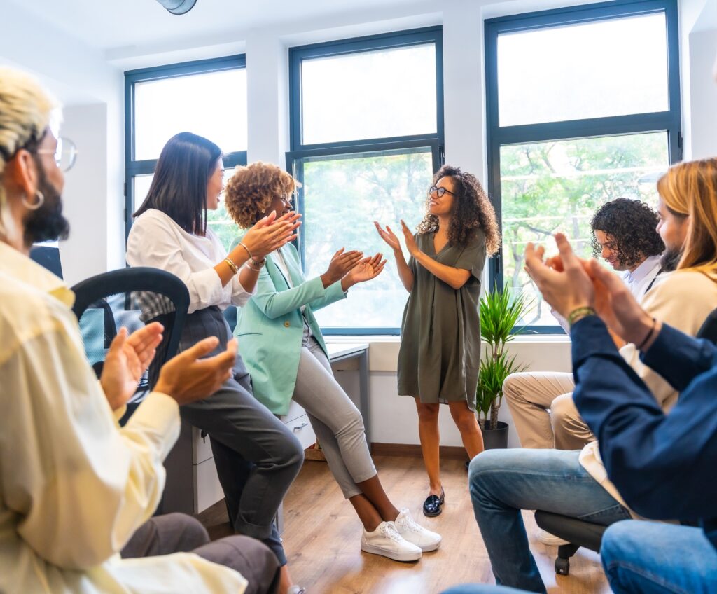 Colleagues congratulating an african woman in a coworking