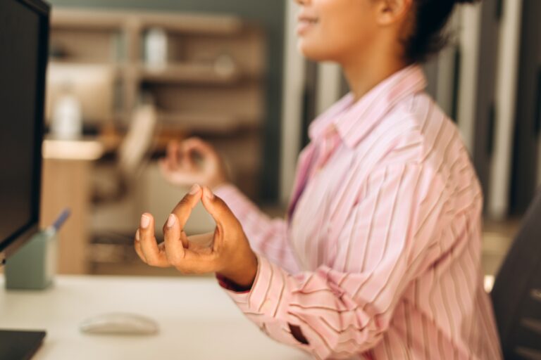 Office worker meditating at workplace for stress relief and mindfulness